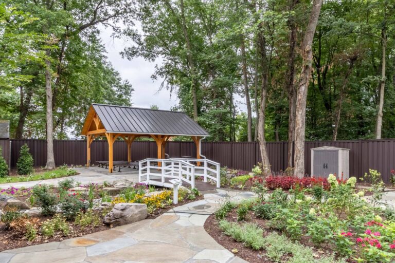 Far view of 20x24 Kingston Timber Frame Pavilion nestled in garden outdoor area