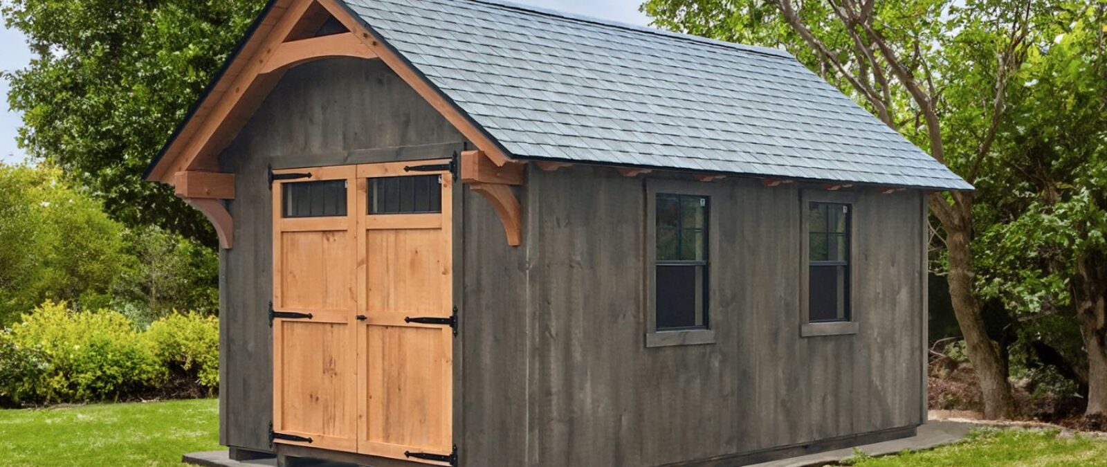 Lancaster Timber Frame Sheds in green yard with timber frame exterior overhand and double wooden doors