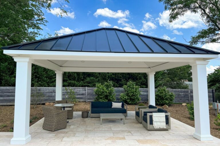 View underneath 16x18 Caribbean Pavilion in Myersville MD. Seating area, white vinyl ceiling, and fence all visible under and behind pavilion