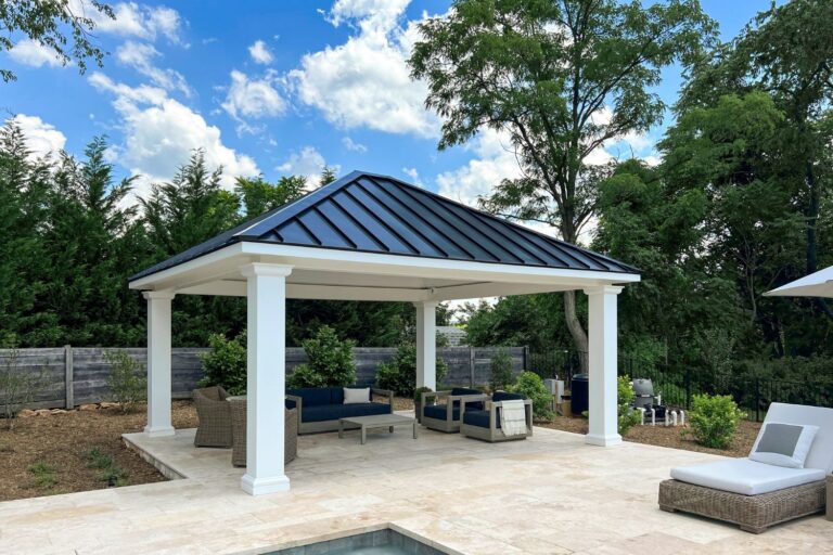 White and black 16x18 Caribbean Pavilion in Myersville MD. Pavilion set on poolside patio with garden in back and seating area underneath