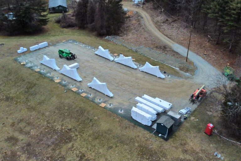 foundation and post brackets of 70x140 Kingston Timber Frame Pavilion in Copake NY. Viewed from the sky. Road, and house also in view
