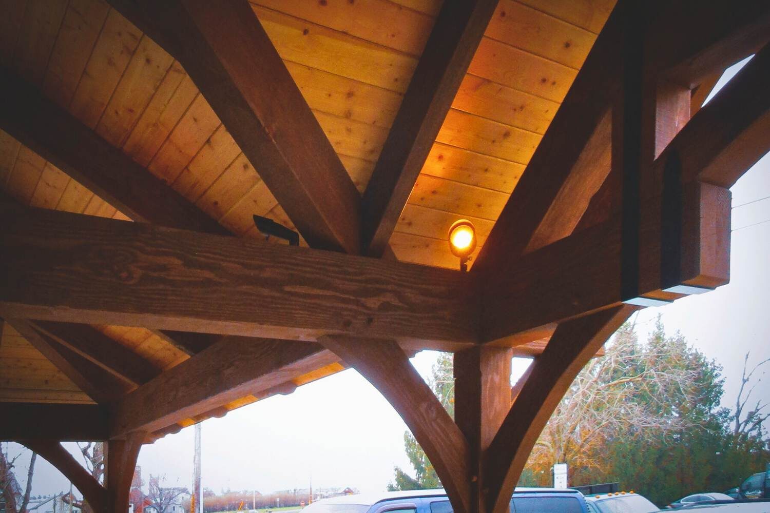 Timber frame pavilion corner with lighting highlighting wood
