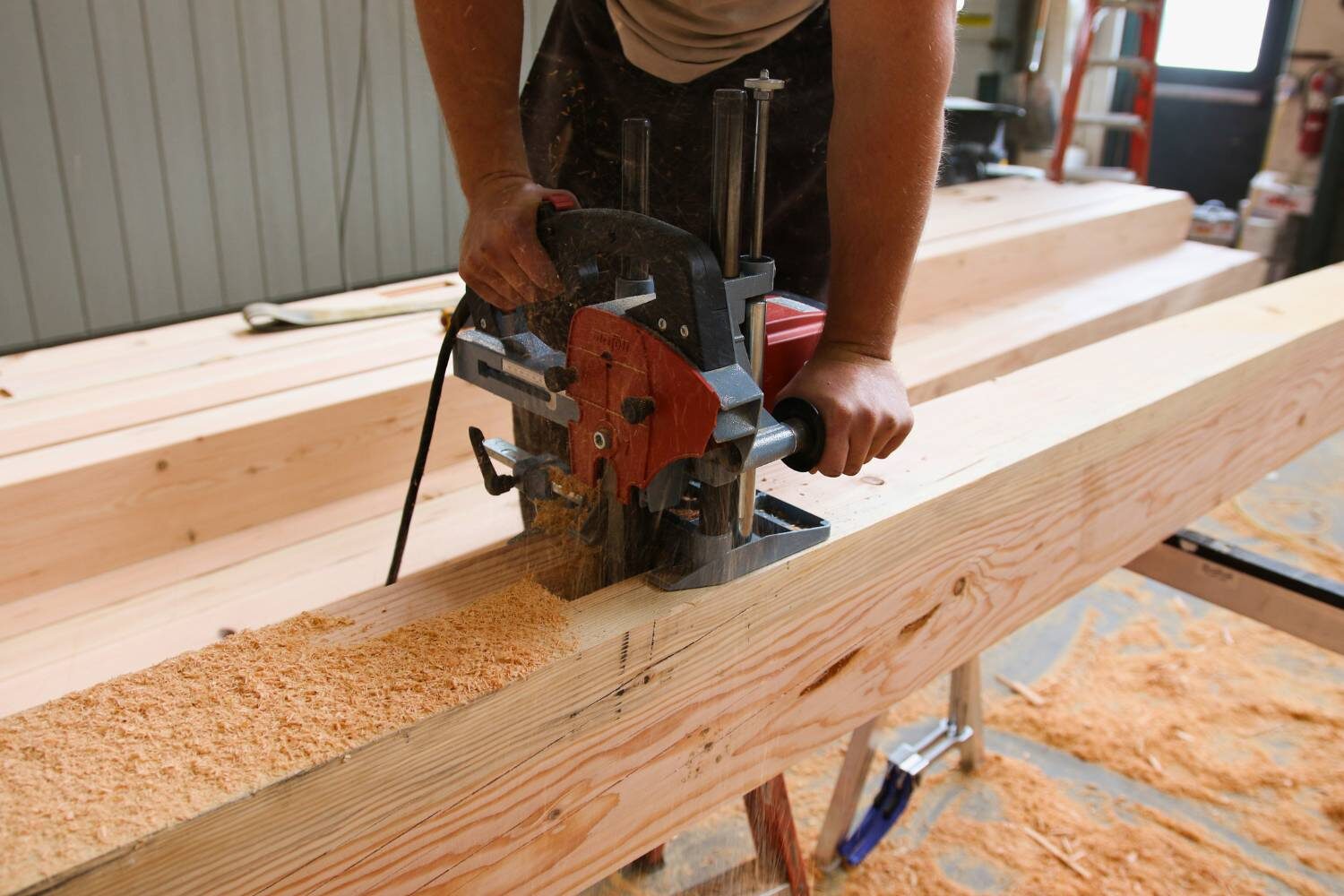 Man carving space in timber for timber frame pavilion
