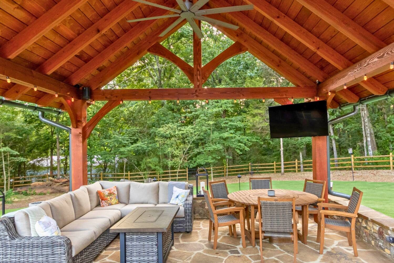 Underneath modern timber frame pavilion with view of truss and timber frame joints