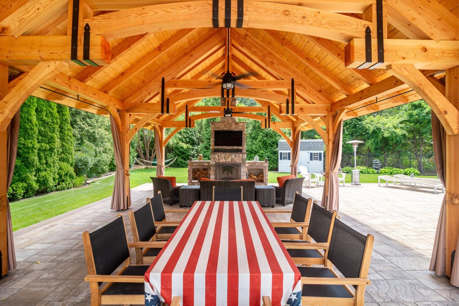 Underneath grand teton timber frame pavilion with view of seating, TV and fireplace