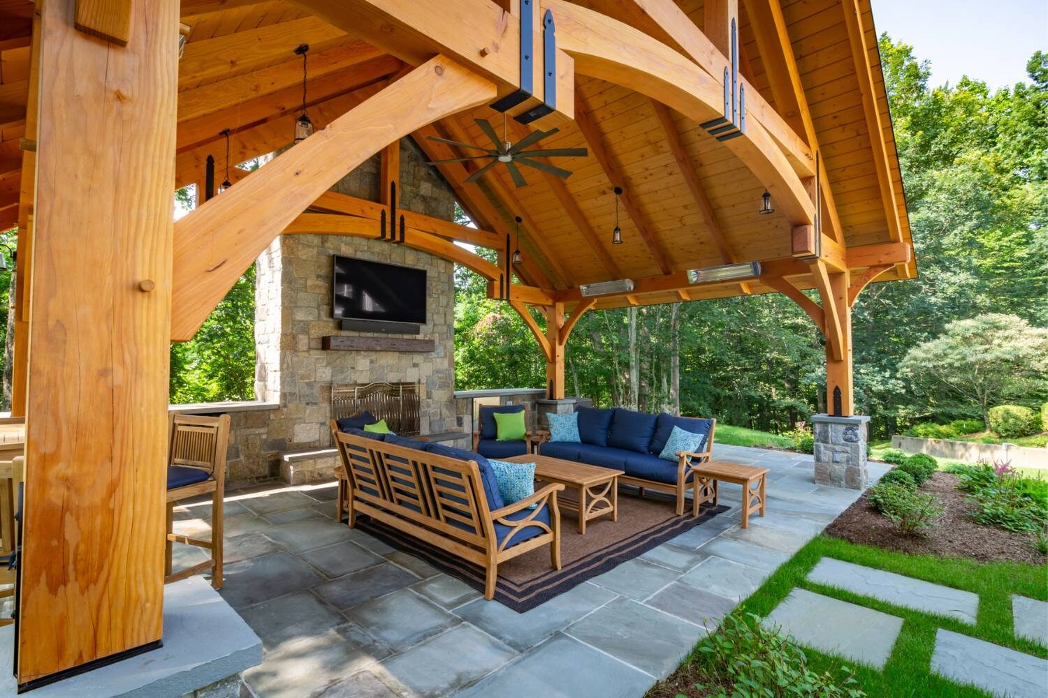Grand Teton timber frame pavilion with seating underneath and besides fireplace