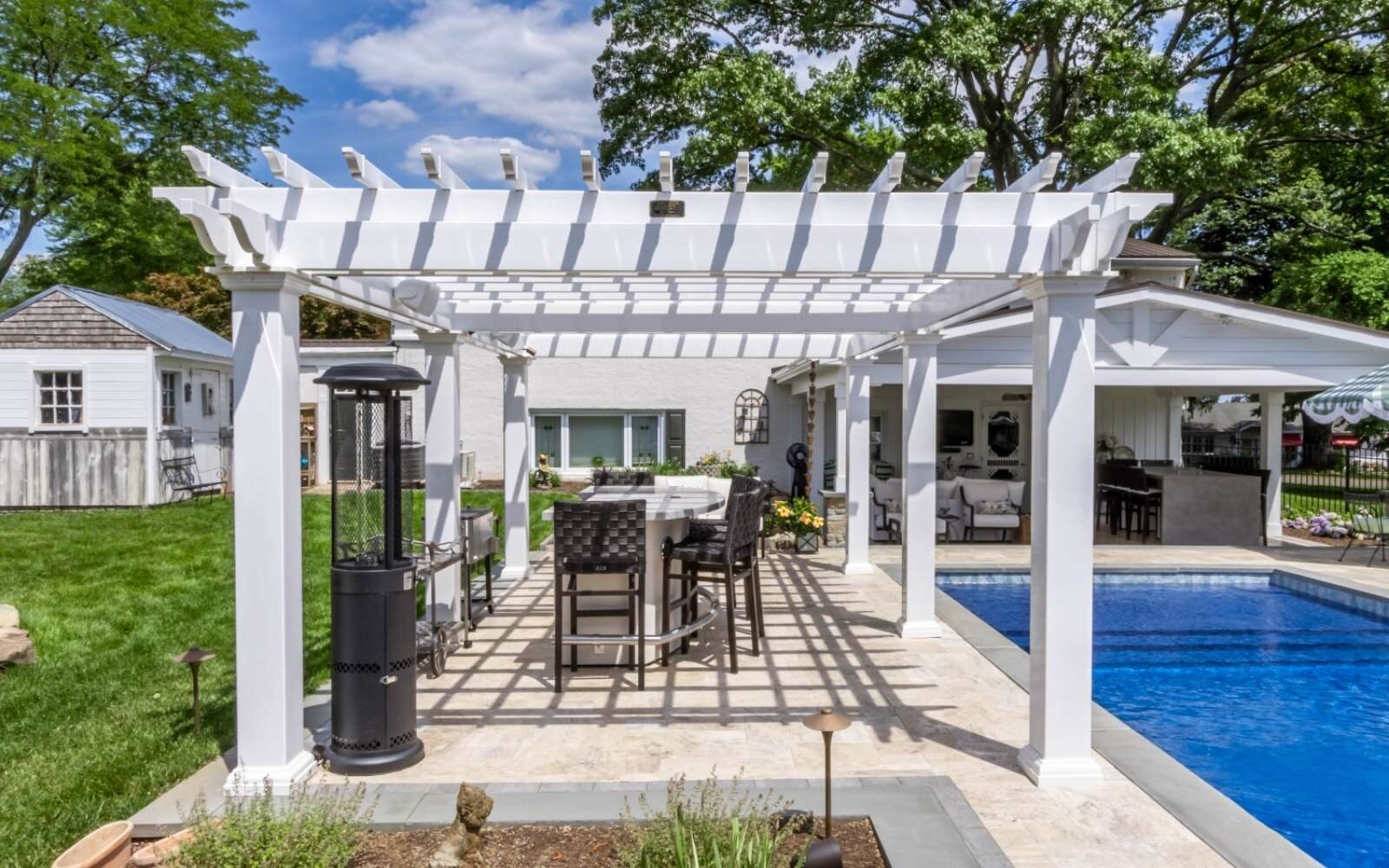 Vinyl Pergola besides pool with seating underneath