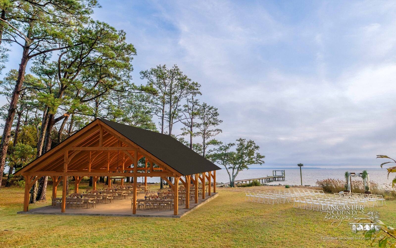 Custom Denali Timber Frame pavilion by lake with seating underneath