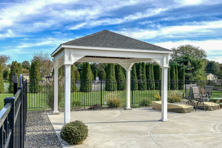 White vinyl pavilion with black roof installed on concrete patio in a landscaped backyard in Woolwich Township, NJ.