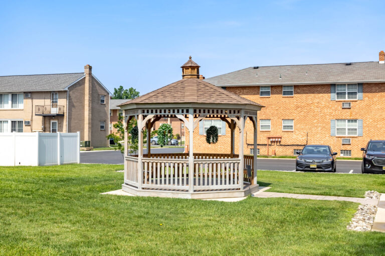 wooden octagon gazebo on green field.