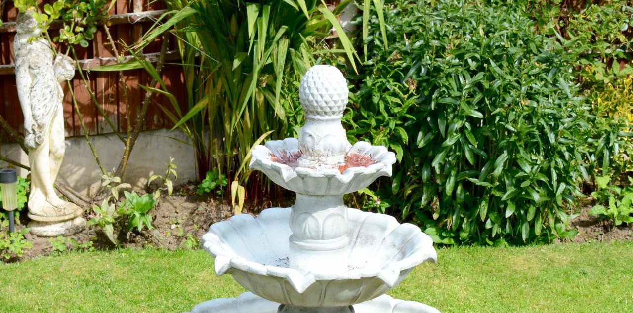 White garden fountain in backyard