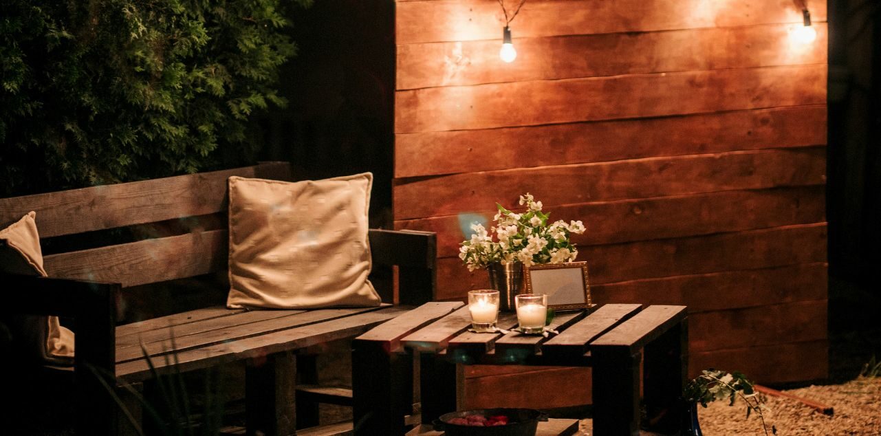 Outdoor couch and table with wooden backdrop and lighting