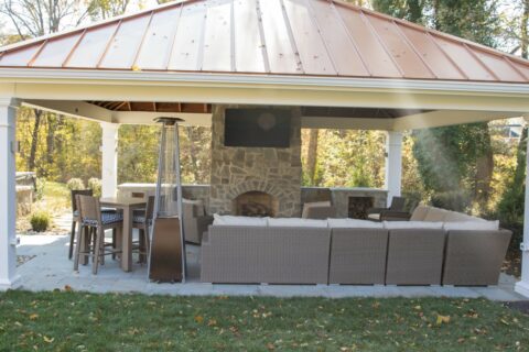 hangout area in outdoor fireplace under pavilion